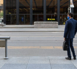 alt="man wearing a face mask waiting for TTC streetcar in Toronto's financial district"